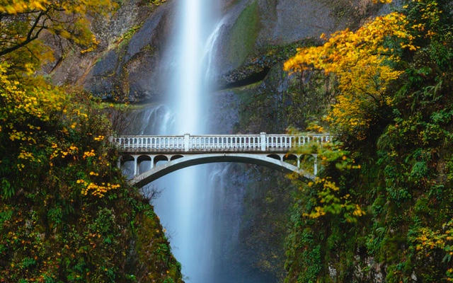 A beautiful bridge with a waterfall behind it
